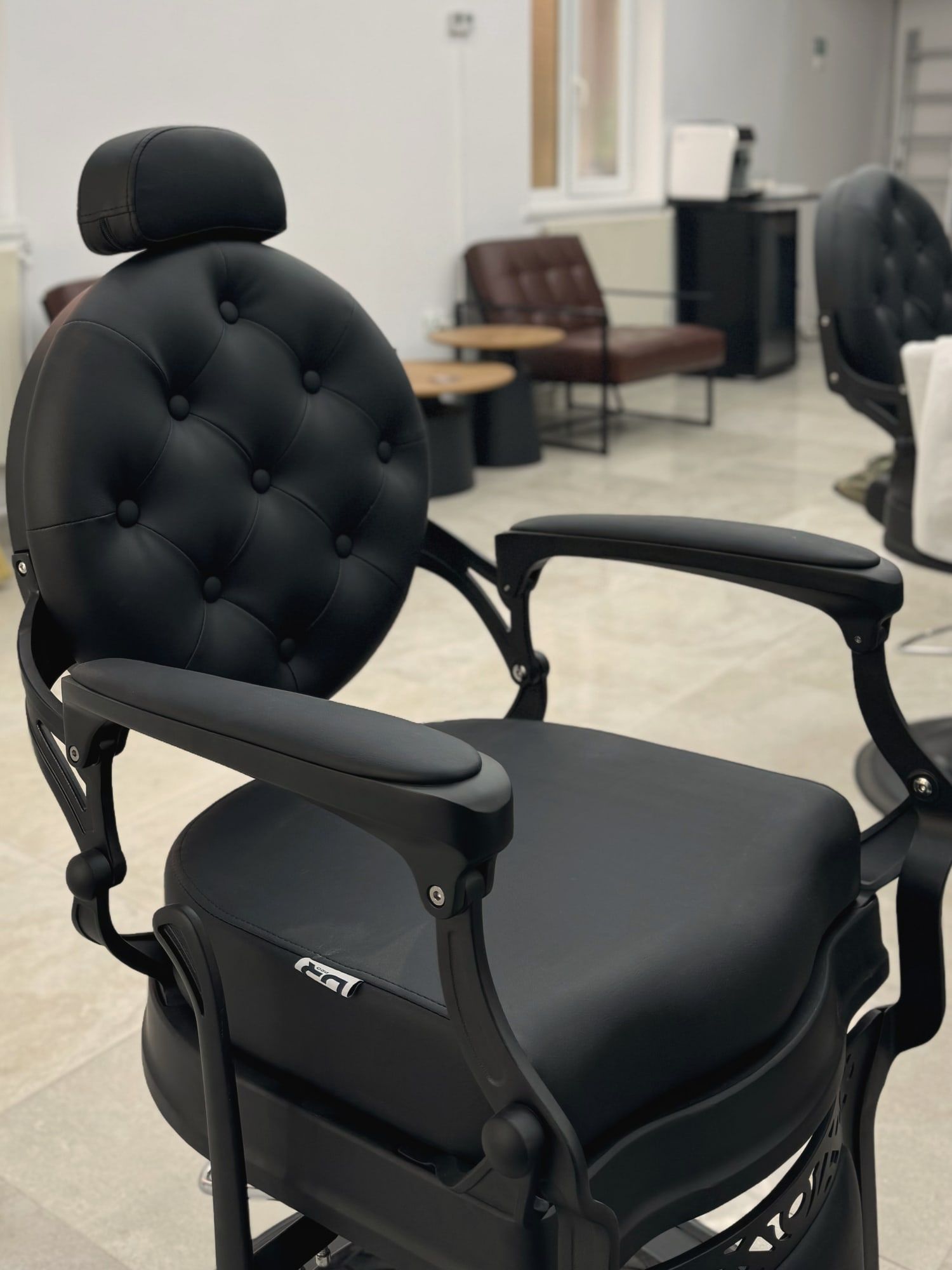 Spătarul capitonat al unui scaun de frizerie vintage, negru